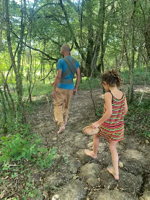 Famille marchant pieds nus sur un chemin en forêt sur le sentier pieds nus du Domaine de Larrous – Domaine de Larrous, Gaujacq (Landes)