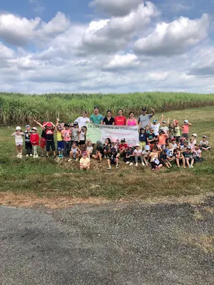 Groupe de visiteurs enfants et adultes posant devant le Labyrinthe de Chalosse dans les Landes lors d’une journée en plein air – Domaine de Larrous, Gaujacq (Landes)